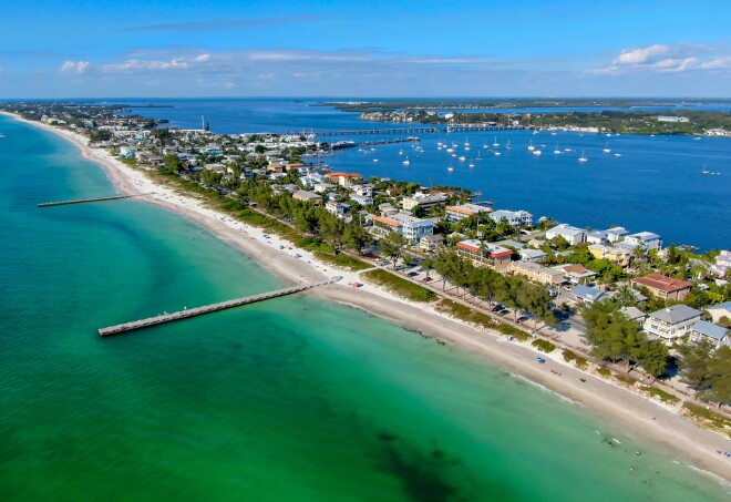 Aerial view of Cortez beach with sand beach, with wooden piers, and beach houses on Anna Maria Island, Florida.